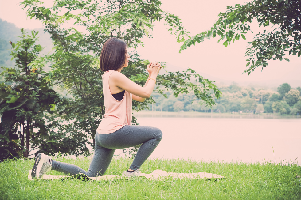 Young Woman Exercising on a Yoga Mat Outdoors